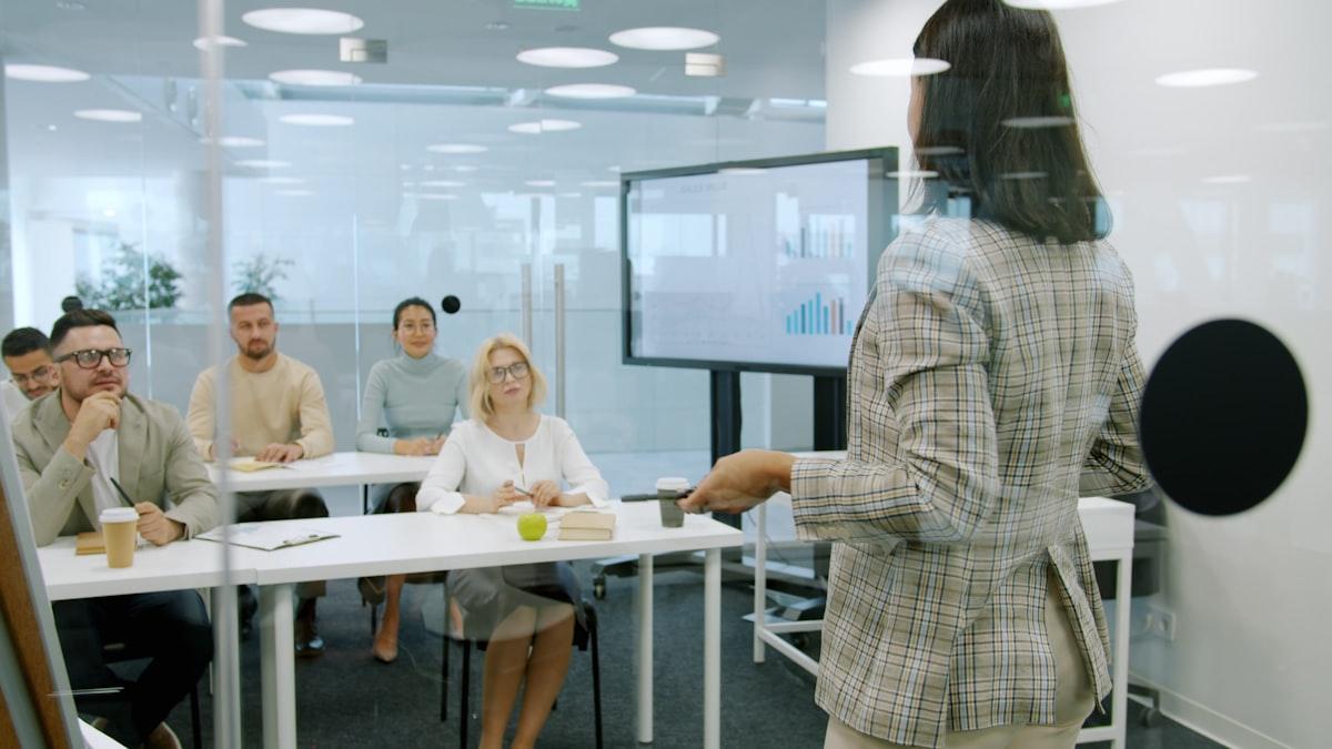Facilitadora presentando estrategias de IA a un grupo de ejecutivos